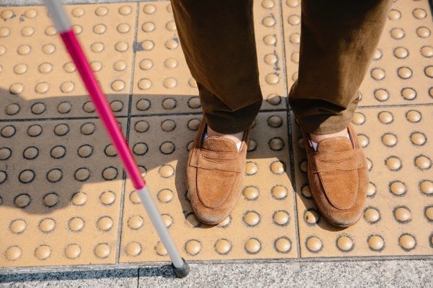 Disabilities in Israel - feet of person with white cane for the blind